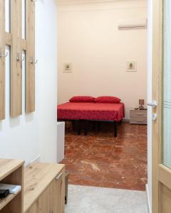 圣维托诺曼Nopal casa vacanze的一间在房间内配有红色床的卧室
