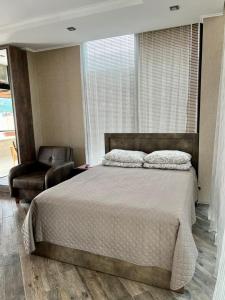 巴统Villa Old Batumi的一间卧室配有一张大床和一把椅子