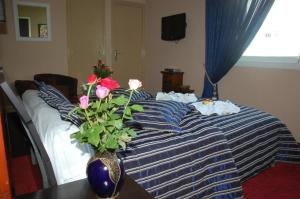 盖尼特拉Ambassy Hotel的一间卧室,配有一张带花瓶的床