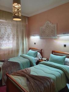 盖尼特拉Ambassy Hotel的一间卧室设有两张床和窗户。