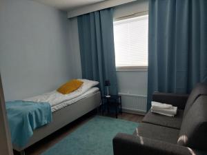 米凯利Ristimäenkatu的一间卧室配有一张床、一张沙发和一个窗口