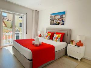 阿威罗Central Tiled Apartment的一间卧室配有一张带红色毯子的大床