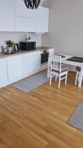 塔林Апартамент у моря的厨房铺有木地板,配有白色橱柜。