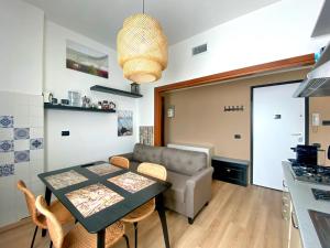 佩罗Rho Fiera Milano Apartment的厨房以及带桌子和沙发的客厅。