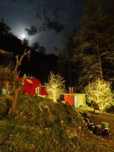 马拉里Last Stop Riverside wooden Huts, Camps & Dorms的一群晚上在山头上灯火通明的建筑
