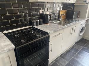 沃特福德Spacious 3 bed flat near Watford Junction的厨房配有黑炉和水槽。