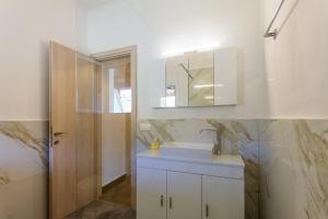 卡西奥皮Kampos Kassiopi Apartment的白色的浴室设有水槽和镜子