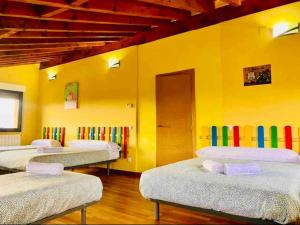 La LosaVilla Arboleda的黄色墙壁的房间里设有三张床