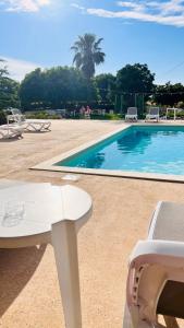 托雷桑塔萨宾娜I Giardini Dell'Agave的游泳池旁配有白色的桌椅