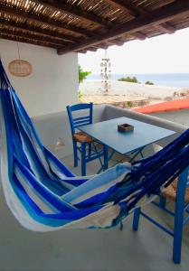 斯科派洛斯Villea Seaview Apartments的庭院里设有蓝色的吊床和桌椅