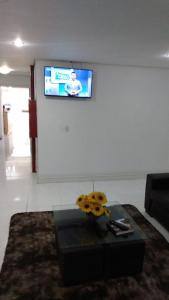 阿雷格里港HOTEL ECONOMICO - 150m Santa Casa, Prox Assembleia e UFRGS的客厅配有桌子,墙上配有电视