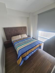 瓜达拉哈拉Departamento con vista increíble en piso 16的一间卧室配有一张铺有木地板的床。