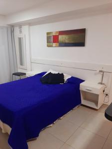 圣米格尔·德·图库玛Hermoso departamento céntrico!的卧室配有蓝色的床和墙上的绘画作品