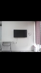 伯萨I can host的白色墙壁上配有平面电视