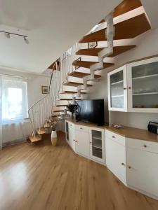 卡姆尼克Apartment Sonata的客厅配有白色橱柜和楼梯