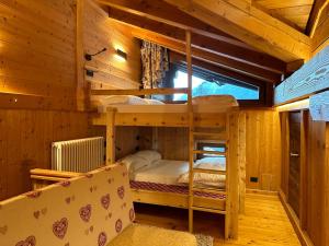 瓦托内切MaisonGorret的小木屋内一间卧室配有双层床