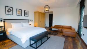 萨姆松Be Side Hotel的卧室配有一张白色的大床和一张沙发。