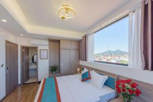 谅山LONG VŨ HOTEL的一间卧室设有一张床和一个大窗户