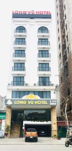 谅山LONG VŨ HOTEL的停在大楼前的汽车