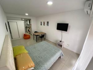 罗萨里奥Depto zona centro muy comodo.的客房设有一张床和一张桌子及一台电视