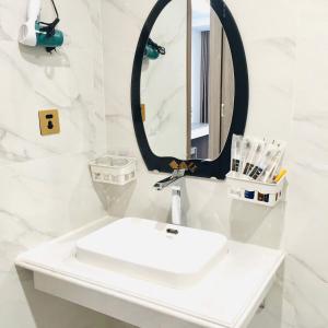 谅山LONG VŨ HOTEL的白色的浴室设有水槽和镜子