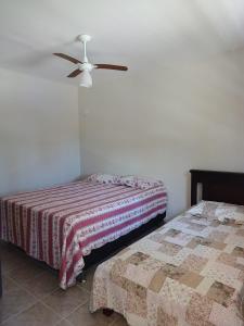 阿瓜斯迪林多亚Chácara Rancho Fundo的一间卧室配有两张床和吊扇