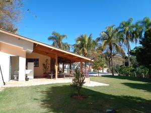 阿瓜斯迪林多亚Chácara Rancho Fundo的棕榈树绿色庭院度假屋