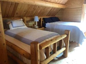 Beddington Lake Log Cabin的小木屋内一间卧室,配有一张床