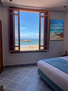 索维拉Riad Mellah的一间卧室设有窗户,享有海滩美景