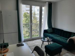 巴黎Magnifique Studio de 25 m2的客厅设有绿色沙发和窗户。