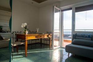 奇维塔韦基亚MARE FUORI APARTMENT的一间带木桌的客厅和一个阳台