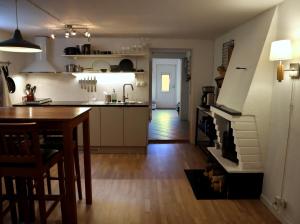 DockstaApartment with Terrace in the Swedish High Coast的一间带桌子的厨房和一个带壁炉的厨房