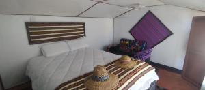 普诺CHUYPAS DEL TITICACA的一间卧室,配有一张带两顶帽子的床
