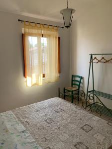 卡斯蒂戈隆·多尔希亚La Mandola的卧室配有床、椅子和窗户。