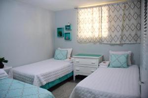 圣塔芭芭拉-山美纳Apartamento entero en Samaná Los tios的一间卧室设有两张床、一个梳妆台和窗户。
