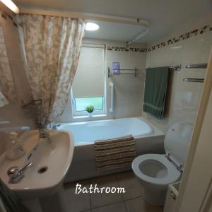 斯莱戈Clover Cottage的带浴缸、盥洗盆和卫生间的浴室