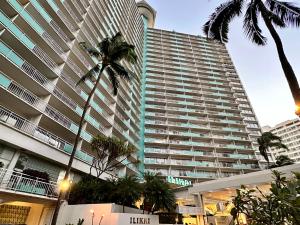 檀香山Serenity Waikiki ! Luxury Ocean Suite !的一座棕榈树环绕的大建筑