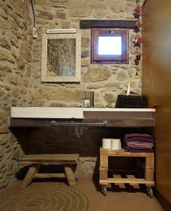 Mieras马斯奥布拉维拉公寓的一间带水槽和石墙的浴室