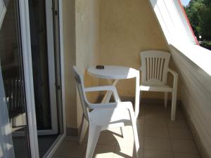 伦蒂Lenti Thermal Panzió的阳台配有一张小桌子和两把椅子
