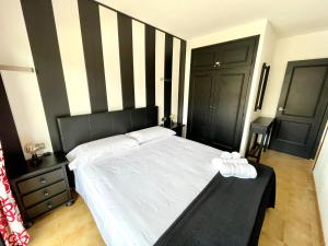 埃斯塔蒂特ALMA BEACH ESTARTIT的一间卧室配有一张带黑白条纹墙的床