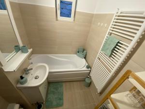 拉姆尼库沃尔恰JACOBS LUXURY Apartaments的带浴缸和盥洗盆的小浴室