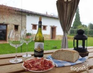 奥维多Sagasta Rural - Oviedo的一张桌子,上面放着一瓶葡萄酒和两杯酒