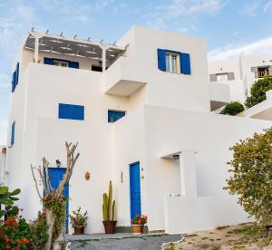 伊奥斯乔拉Cozy little house in Ios的白色的房子,有蓝色的门和植物