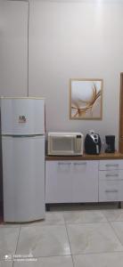 卡鲁阿鲁Casa Confortável的厨房配有冰箱和微波炉