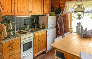 阿尔博加3 Bedroom Lovely Home In Arboga的厨房配有木制橱柜和白色炉灶烤箱。