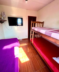 雷森迪Pousada Diniz的客房设有两张双层床和一台平面电视。