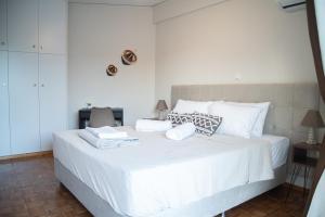 瓦尔基扎Naiads Nest - The Cozy Retreat的卧室配有白色大床和白色枕头