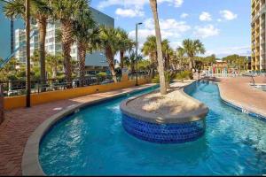 默特尔比奇Caravelle Resort的中间有一个棕榈树游泳池
