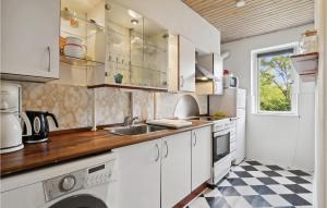 哥本哈根1 Bedroom Cozy Apartment In Valby的厨房配有白色橱柜和 ⁇ 格地板