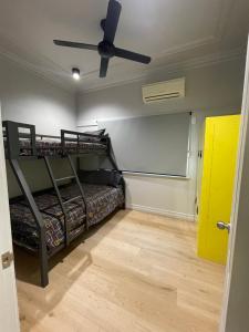 布里斯班Banana Backpackers的客房设有两张双层床和吊扇。
